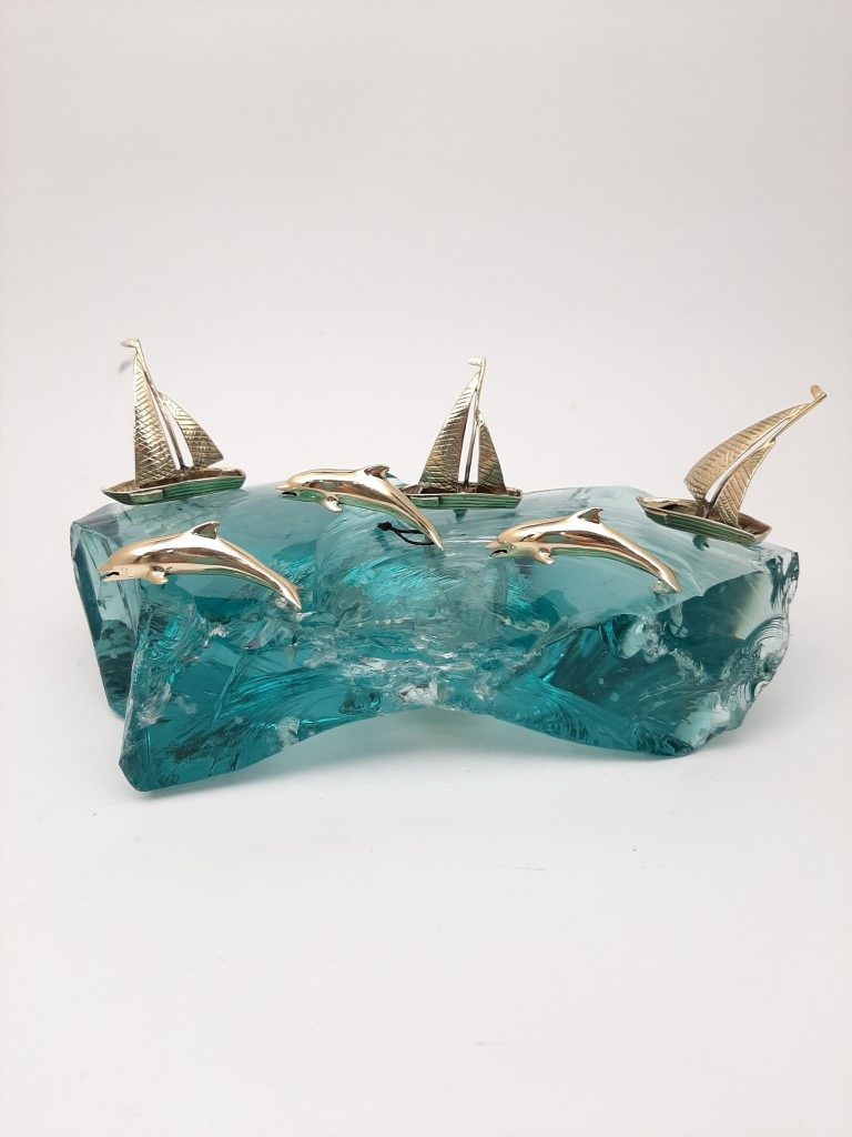 THREE BRONZE SAILING BOATS AND THREE DOLPHINS ON GLASS